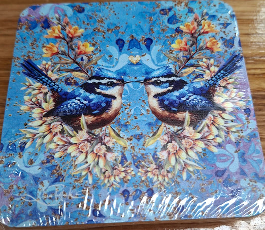 Decorative coaster with blue birds and floral design on a wooden surface