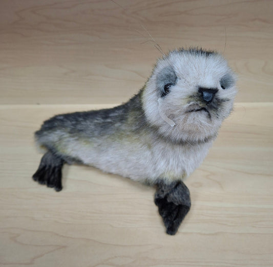 Stuffed otter toy on a wooden surface